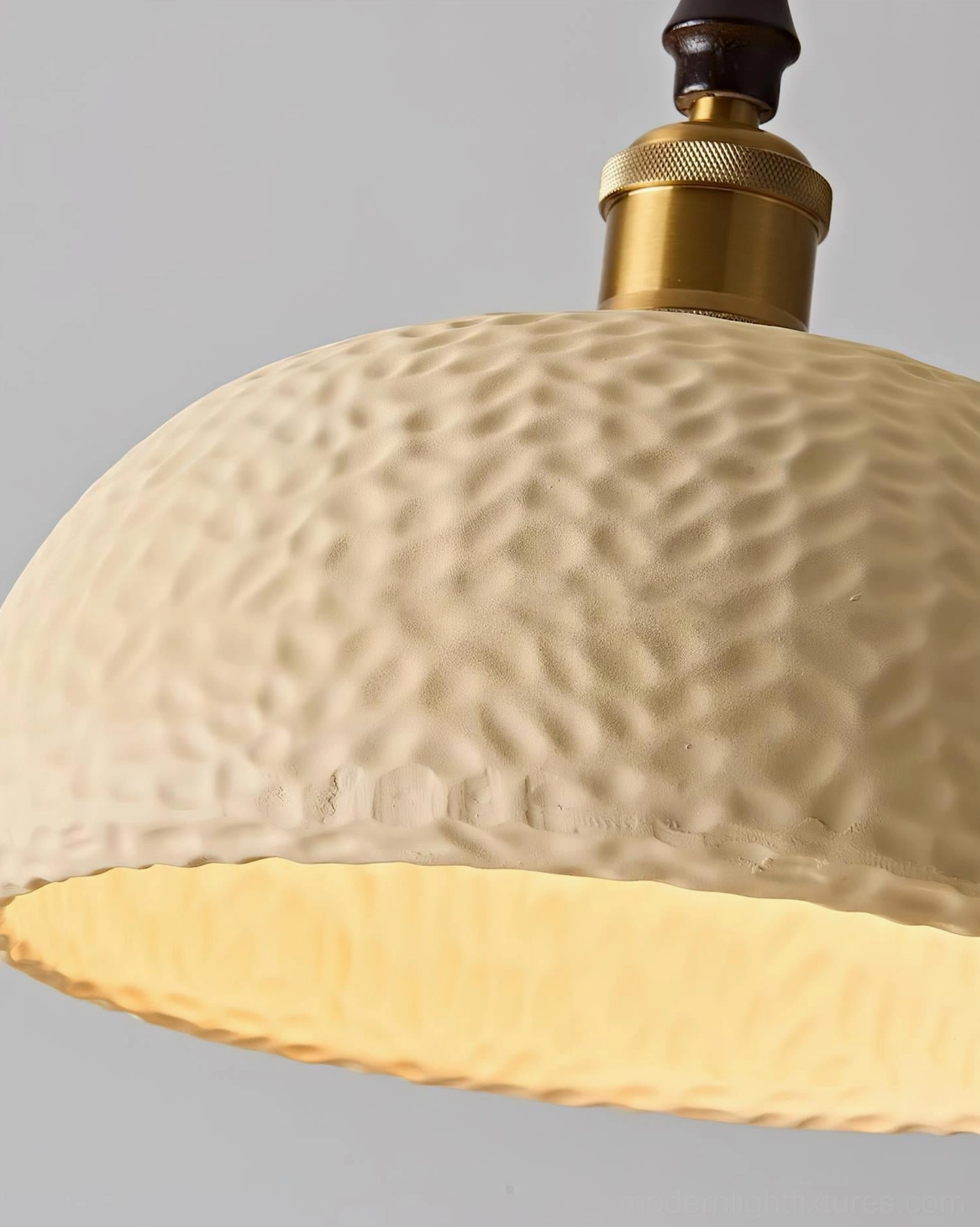 Textured resin pendant lamp close-up showing hammered surface detail and wood neck accent