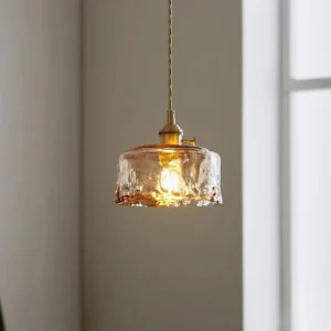 Retro hanging pendant lamp by window with warm glowing amber glass and twisted brass cord