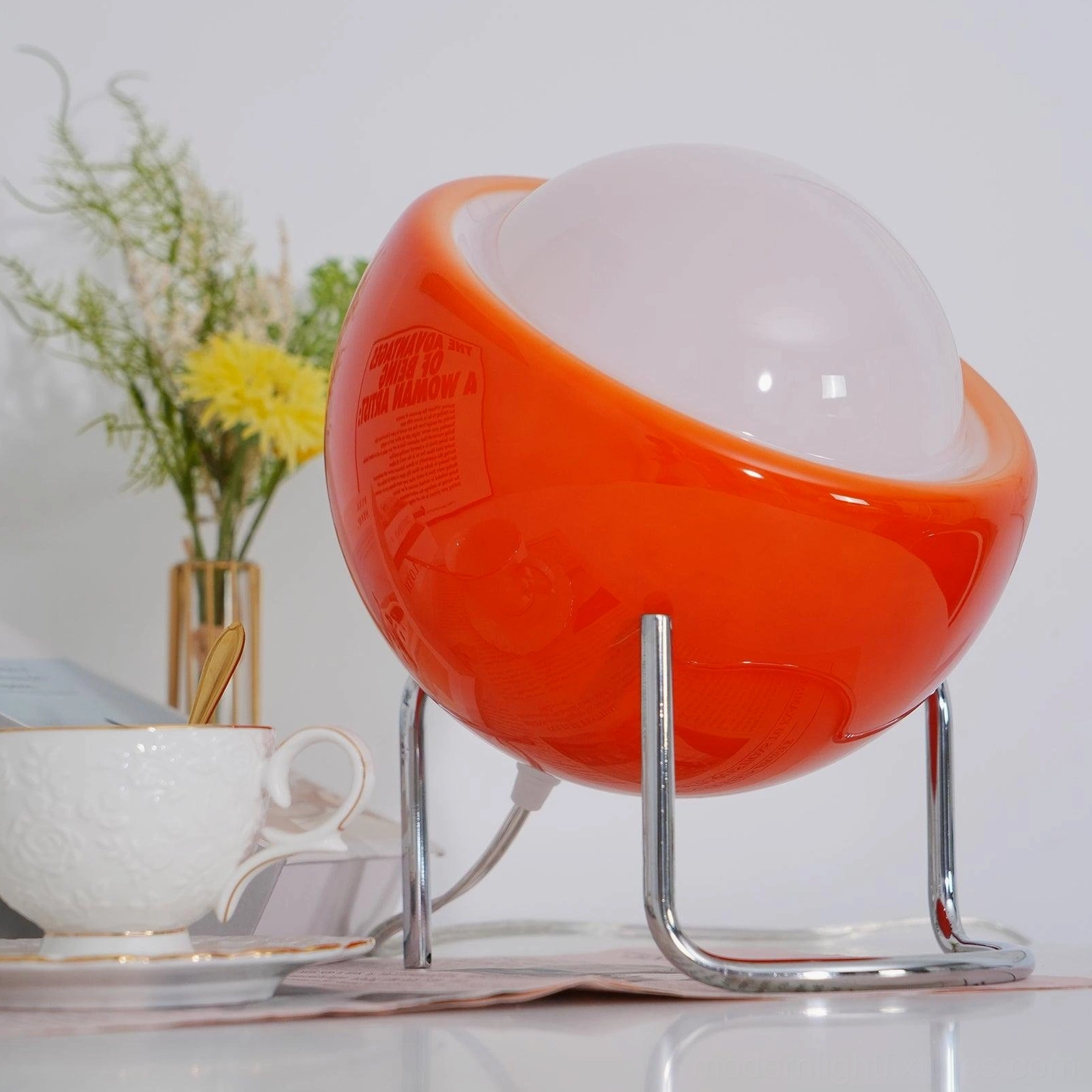 Retro Bauhaus dome lamp with tilted glass sphere on curved metal stand, artistic design perspective
