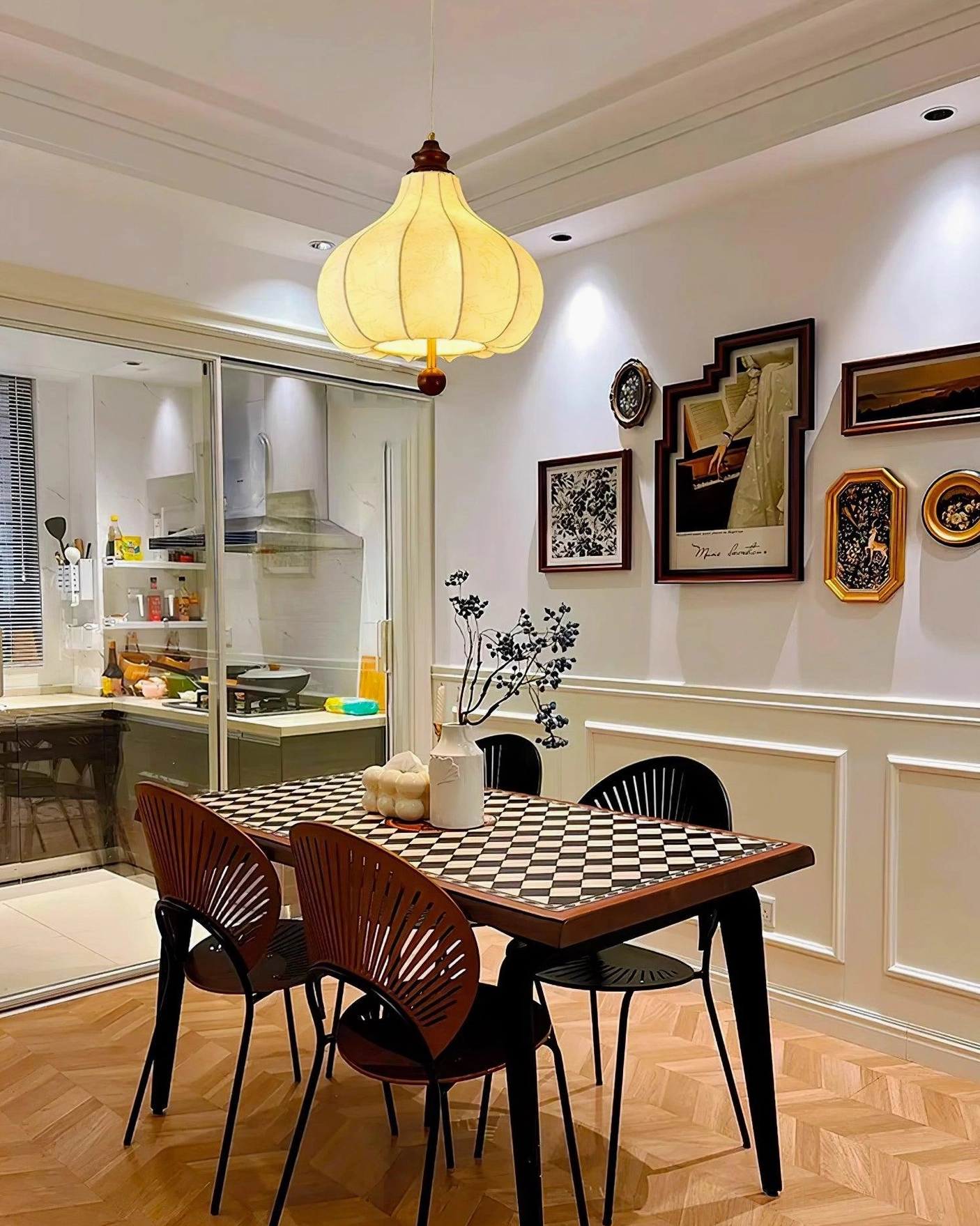 Retro fabric pendant light with yellow-toned shade and brass hardware in modern kitchen-dining area with checkered flooring
