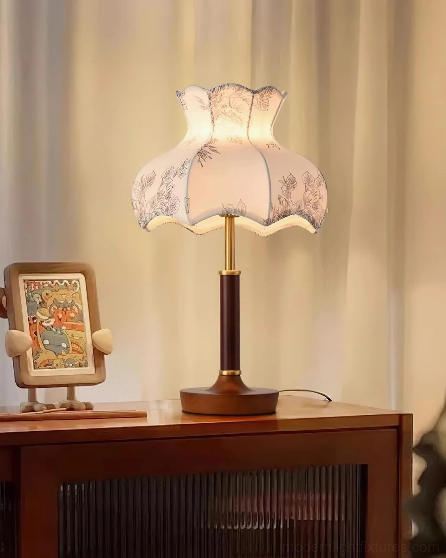 Retro table lamp with botanical print shade displayed on wooden side cabinet, cozy vintage home interior