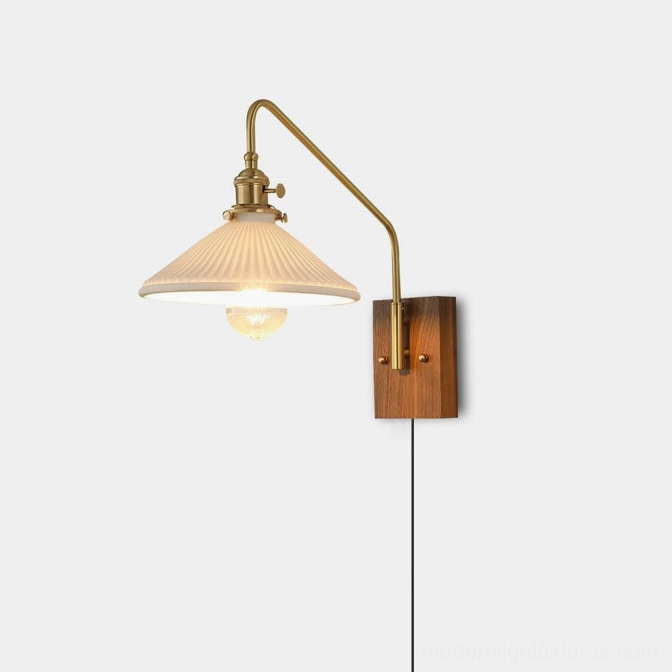 Retro brass and walnut plug-in wall sconce with adjustable swing arm and pleated ceramic shade, three-quarter front view