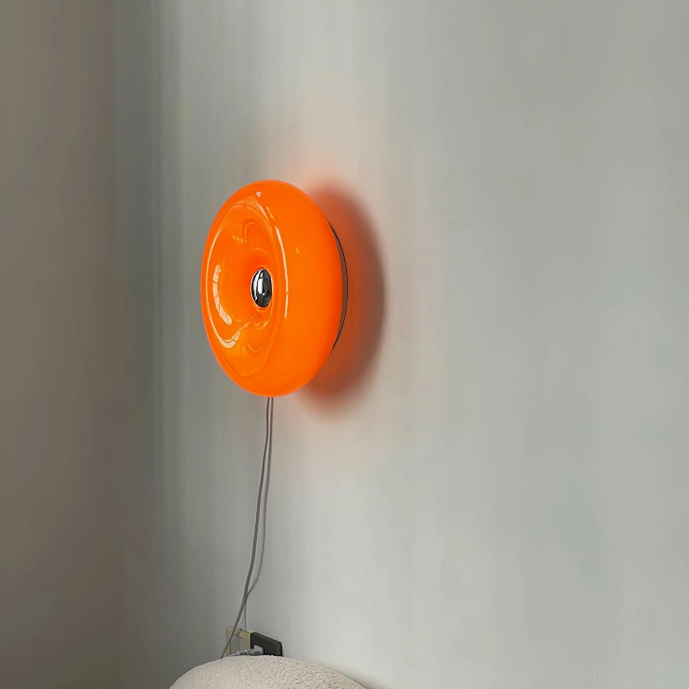 Retro mid-century donut wall lamp with warm orange glow in contemporary interior setting