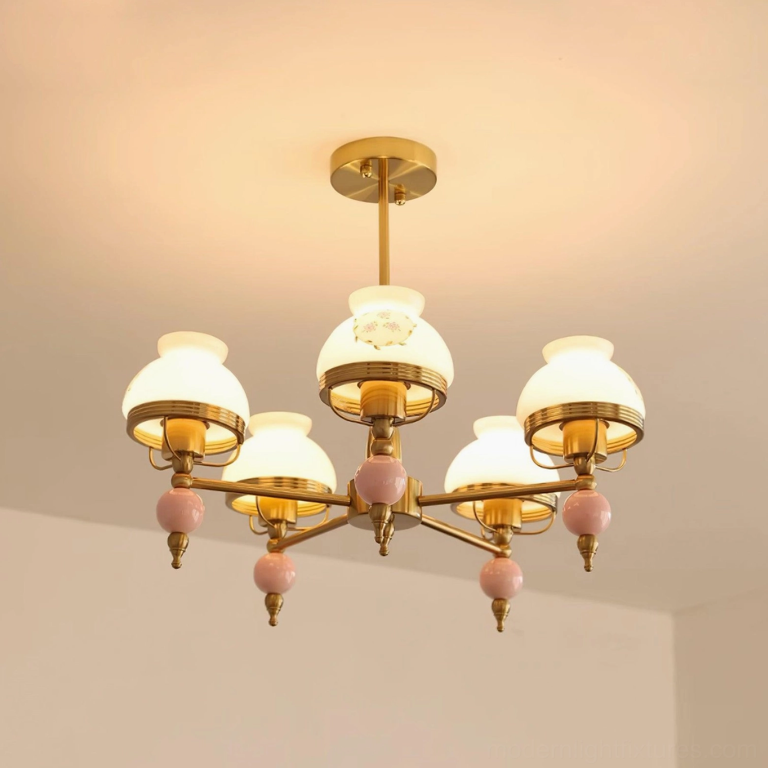 5-head vintage chandelier lit with warm glowing light and pink flower printed glass shades