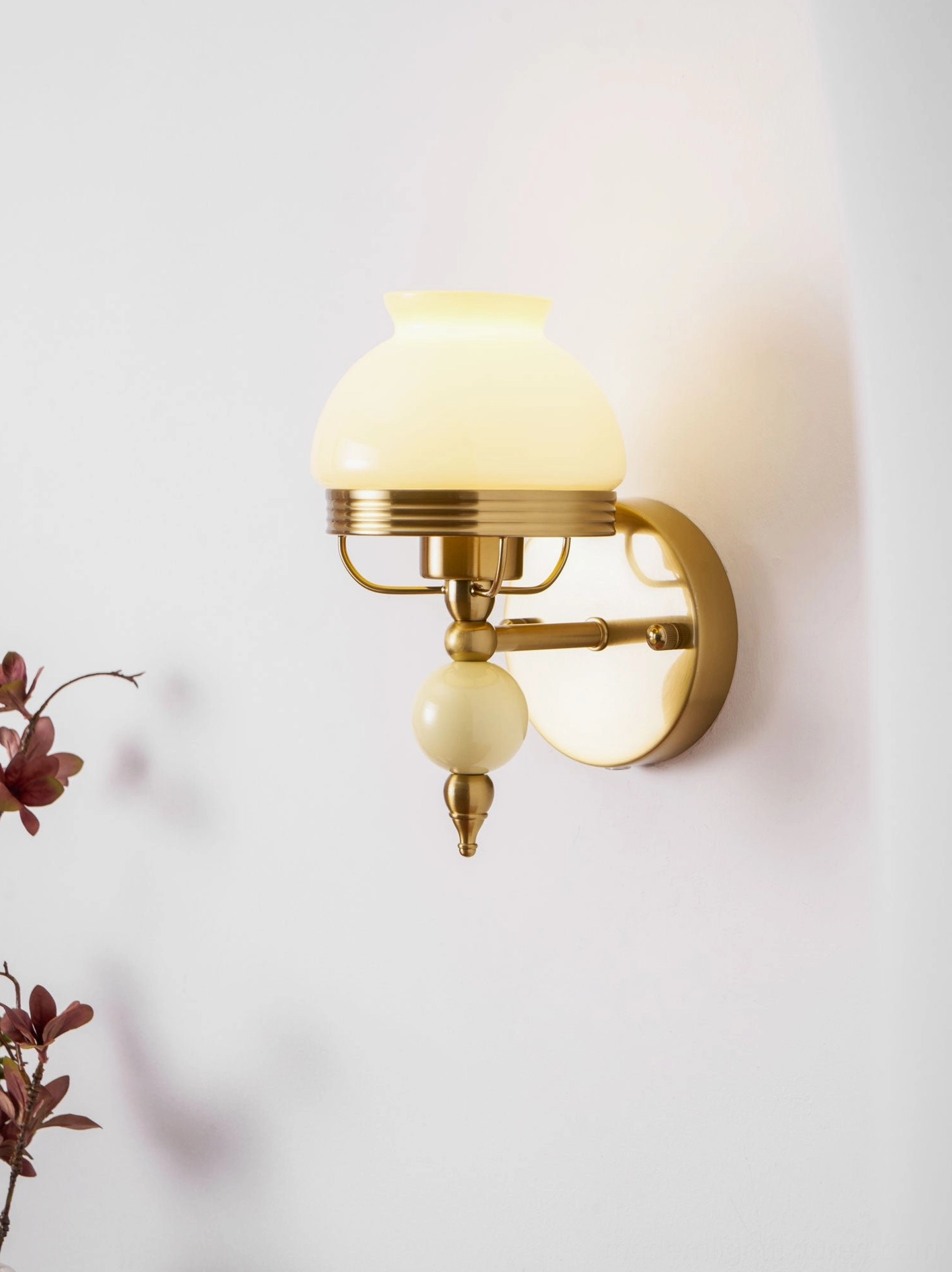 Retro floral wall sconce in warm pink tones with frosted glass and brass frame