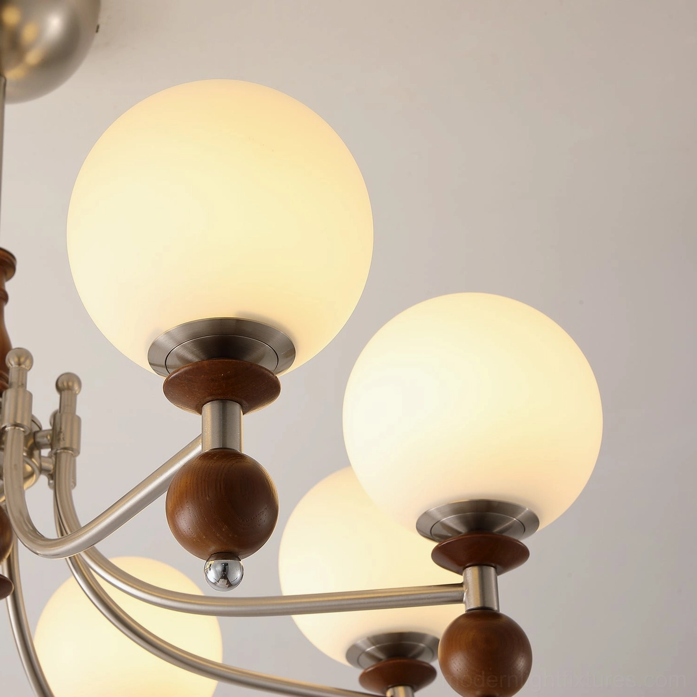 Retro globe chandelier detail showing polished metallic arms and frosted white glass shade craftsmanship