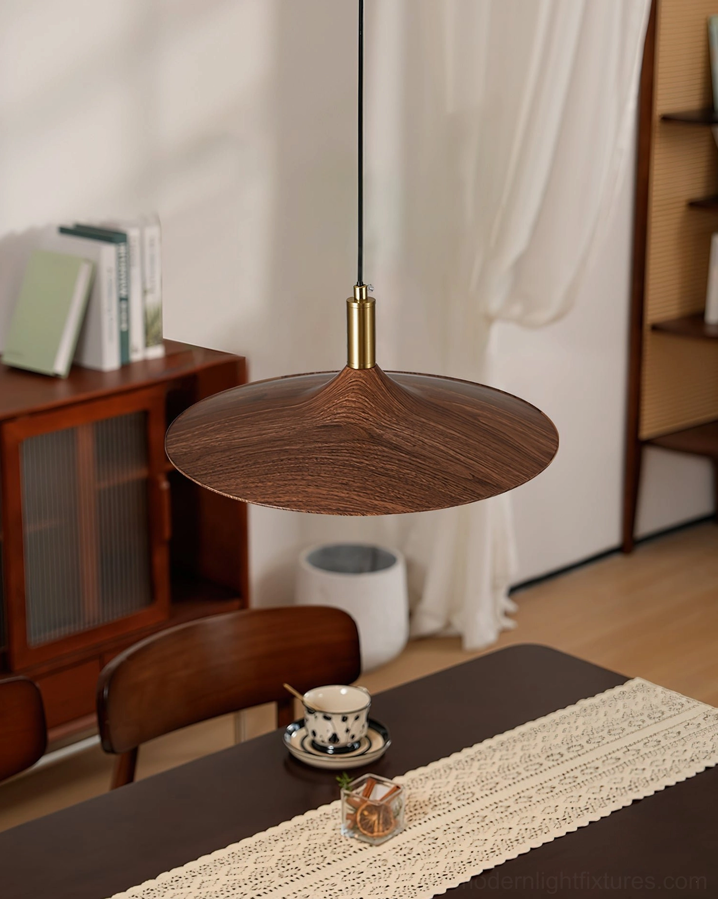 Large walnut wood disc pendant light suspended in formal dining room setting