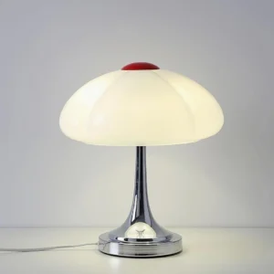 Mushroom table lamp three-quarter view showing milk-white segmented shade with red finial and polished metal components