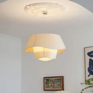 Retro pleated pendant lamp installed on decorative ceiling medallion in Nordic style living room with warm glowing light from below