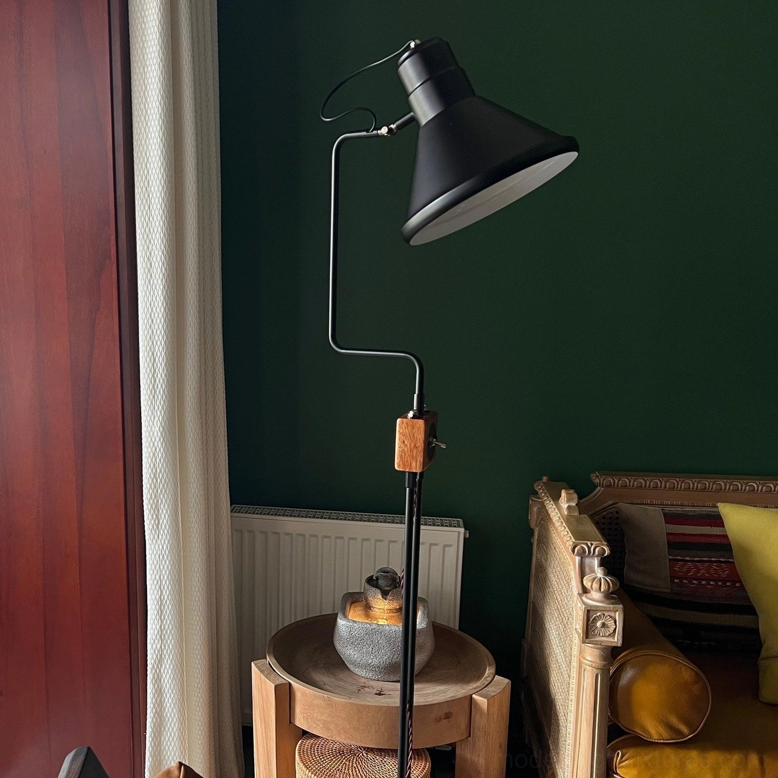 Industrial floor lamp three quarter view dark green accent wall wooden middle accent