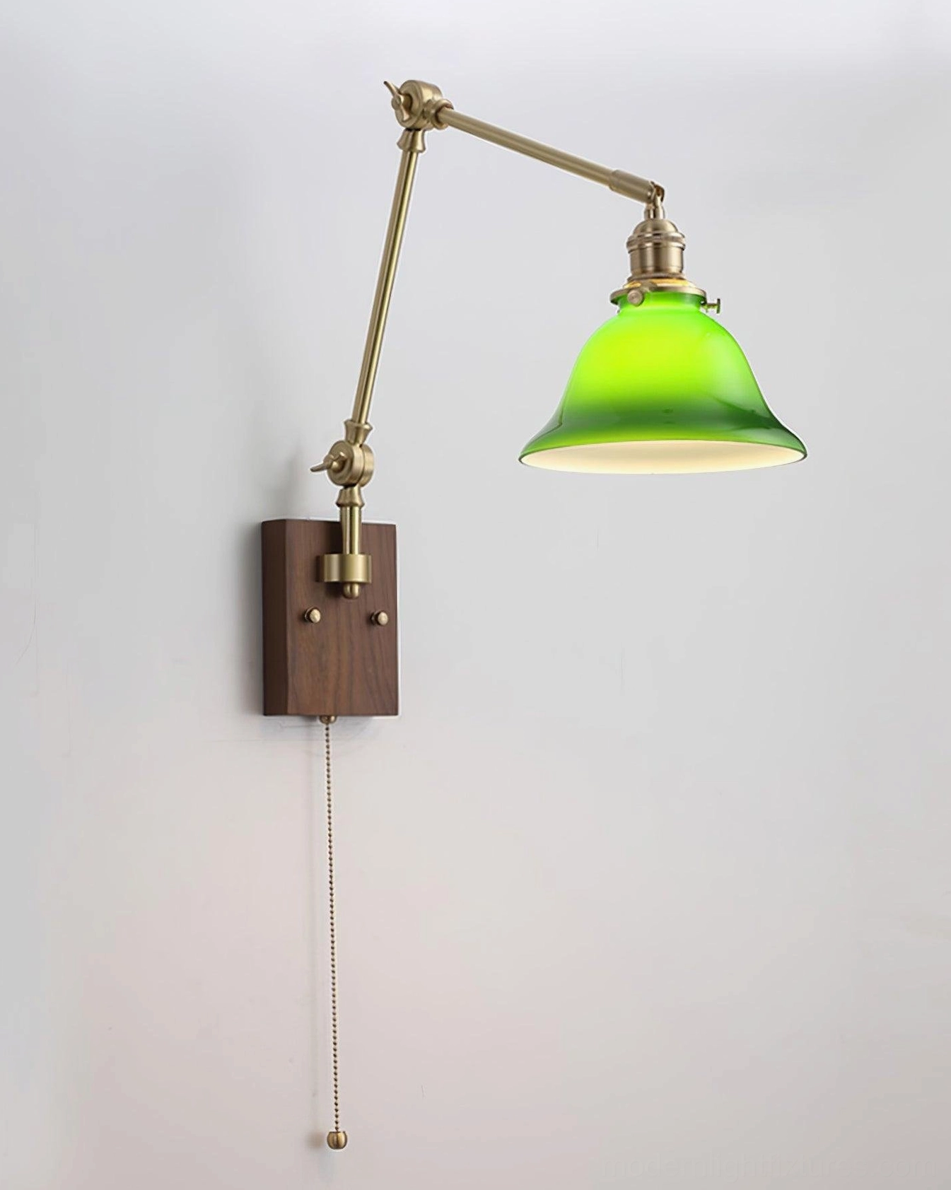 Retro vintage style swing arm wall lamp with green glass dome shade, brass metal arms, and dark wood backplate on plain white background