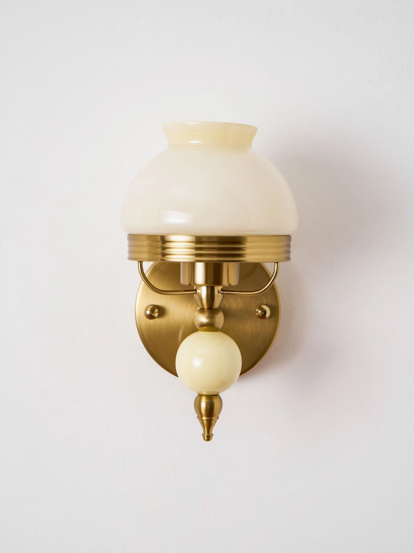 Retro wall lamp in beige tone with frosted glass shade and decorative brass hardware