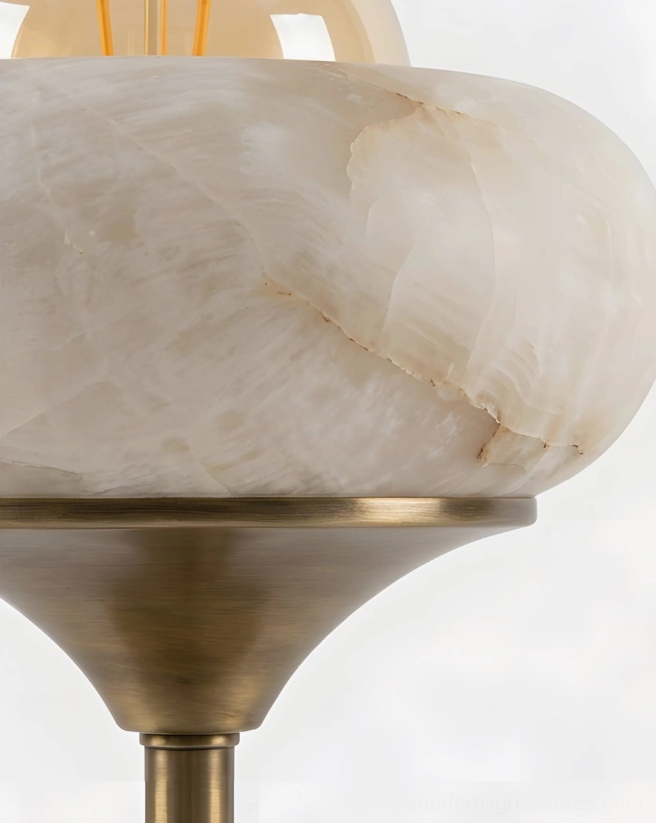 Retrovia alabaster table lamp detail showing push-button switch on brass body, transparent cord, and glass globe bulb in alabaster bowl fixture