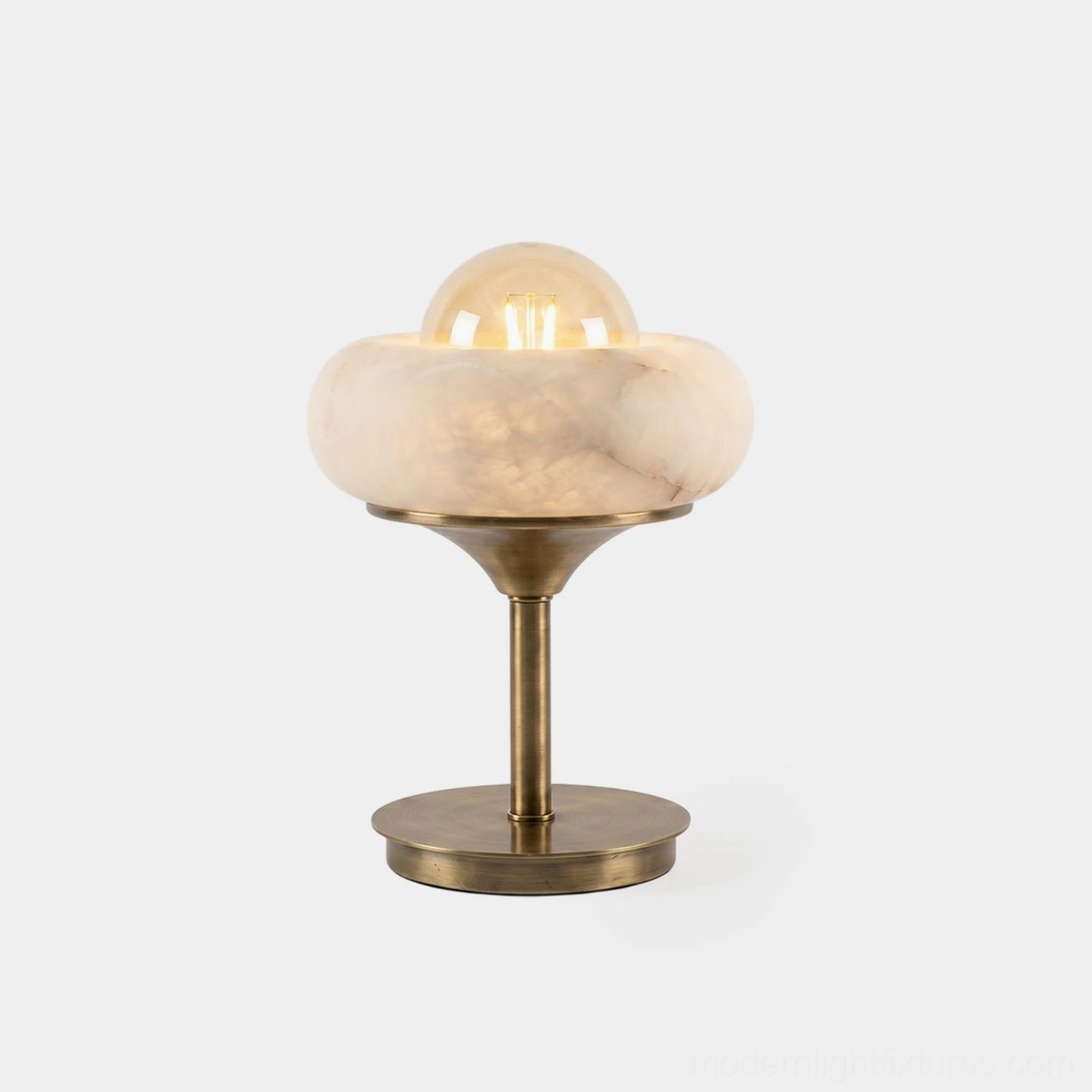 Retrovia alabaster table lamp with brass stem and weighted disc base, featuring exposed glass globe bulb seated in natural stone bowl, studio front view