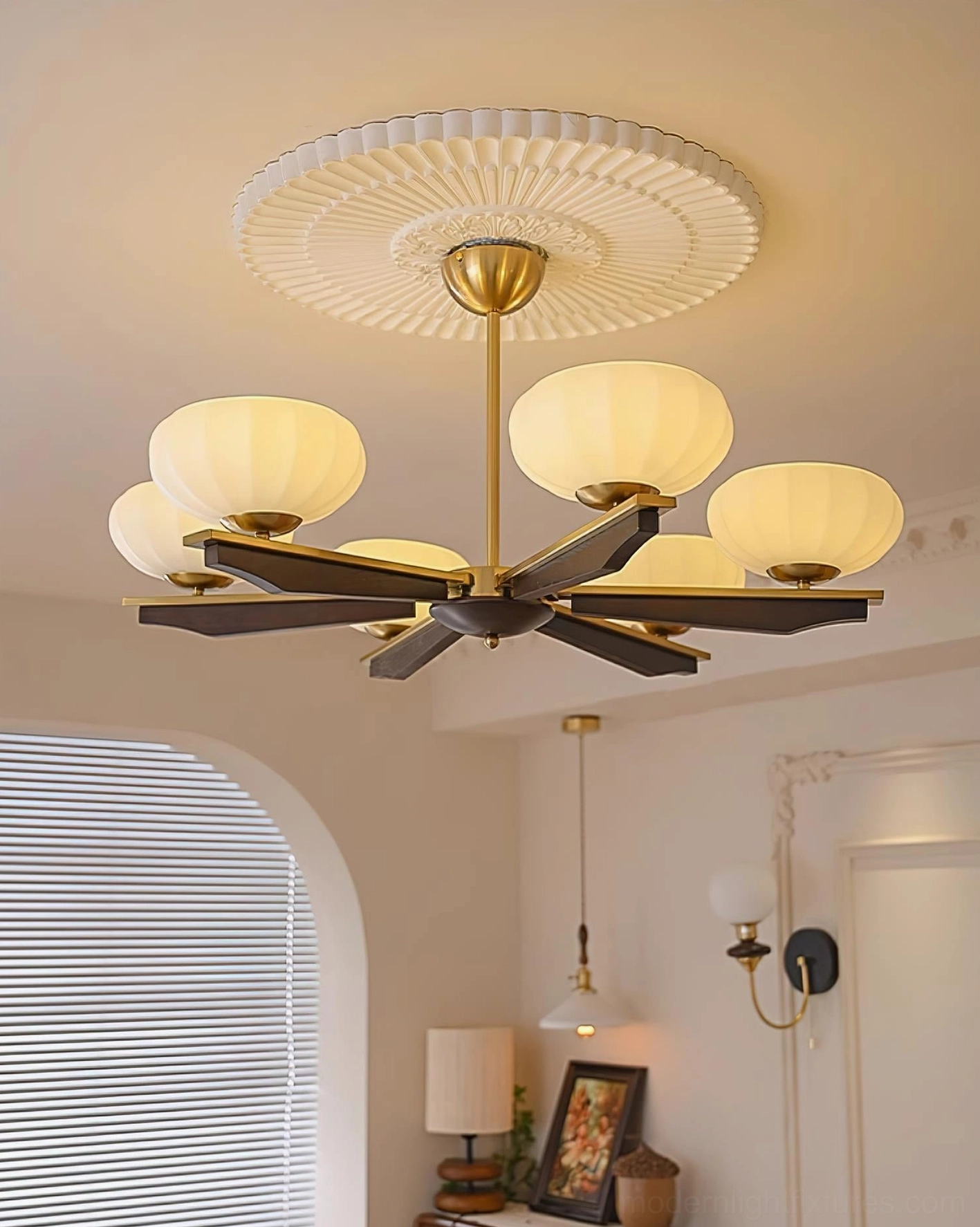Reya 6-arm pendant chandelier with opal glass shades and wooden arms, low angle upward view in residential room with arched window