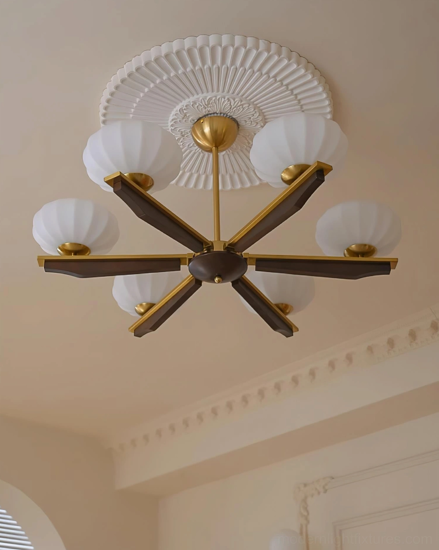 Reya mid-century modern wood chandelier with dark stained wood arms and brass accents, French style interior with embossed ceiling rose