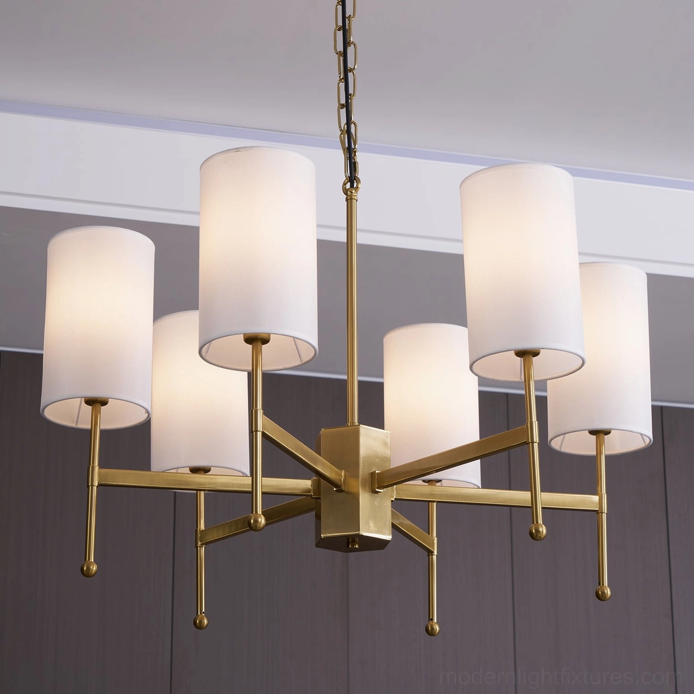 Close-up of brass metalwork and white fabric shade construction on Rhodes modern chandelier