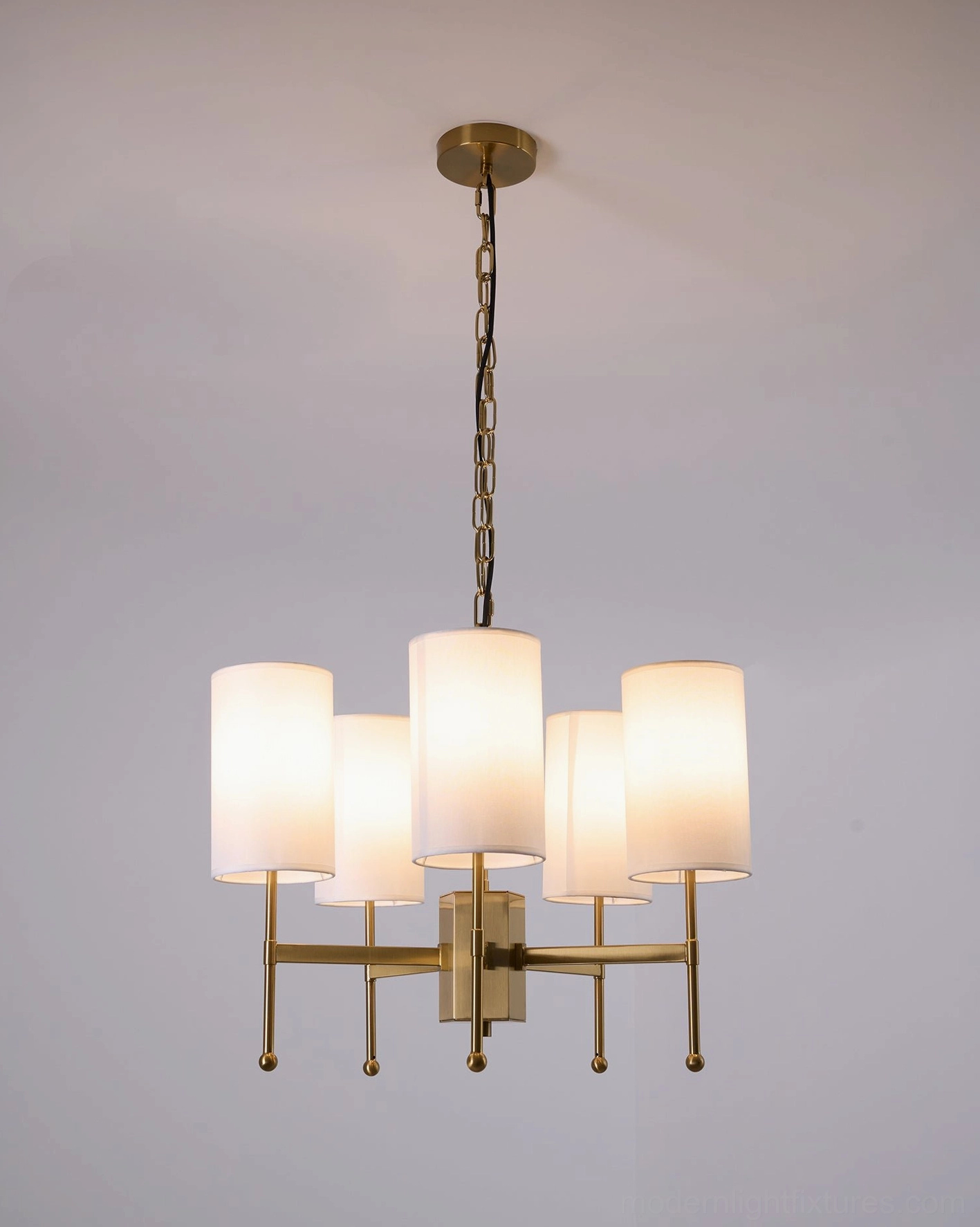 Detail of Rhodes chandelier brass frame quality and white cylindrical shade fabric texture
