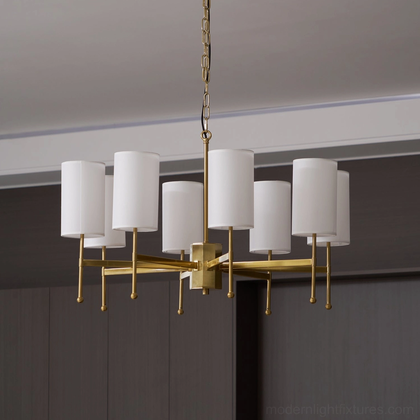 Rhodes 8-light sputnik chandelier with unlit white cylindrical shades against dark wood panel wall - interior view