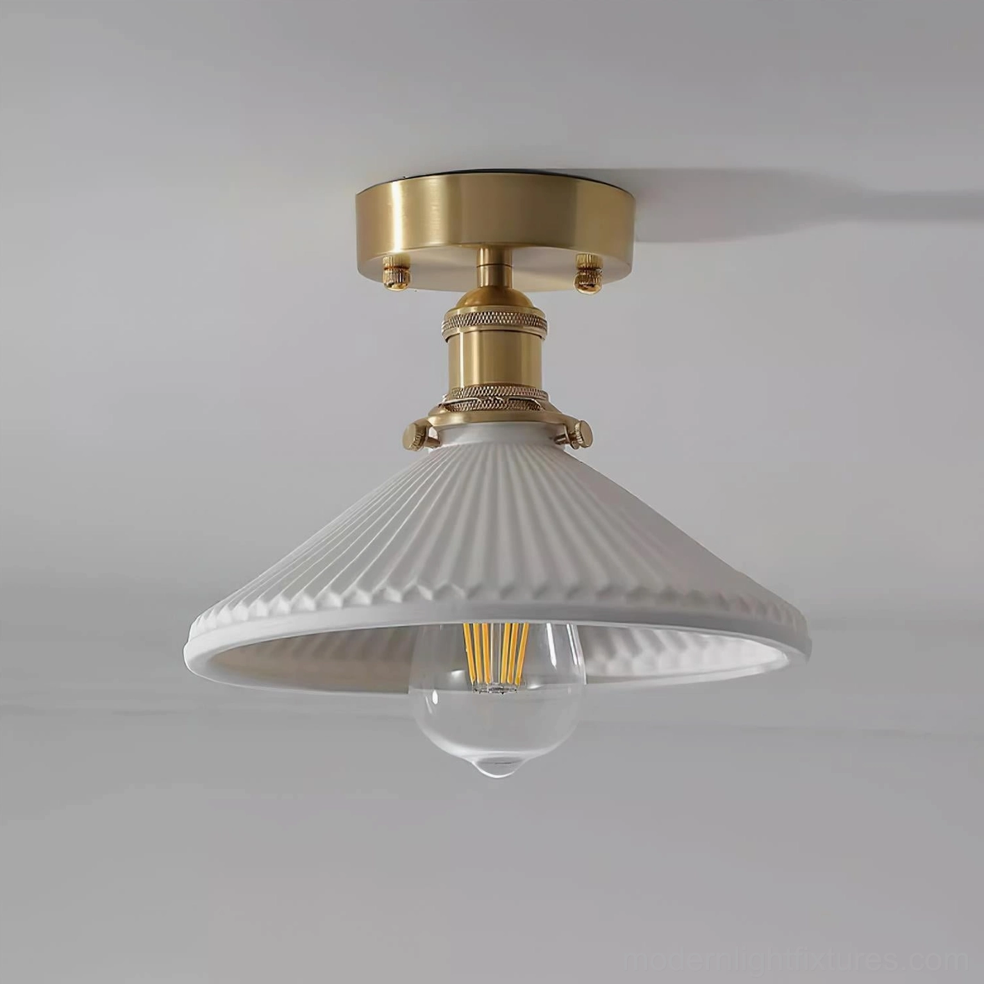 Rialto semi-flush ceiling light studio shot featuring brass mount and ribbed white shade with visible filament Edison bulb