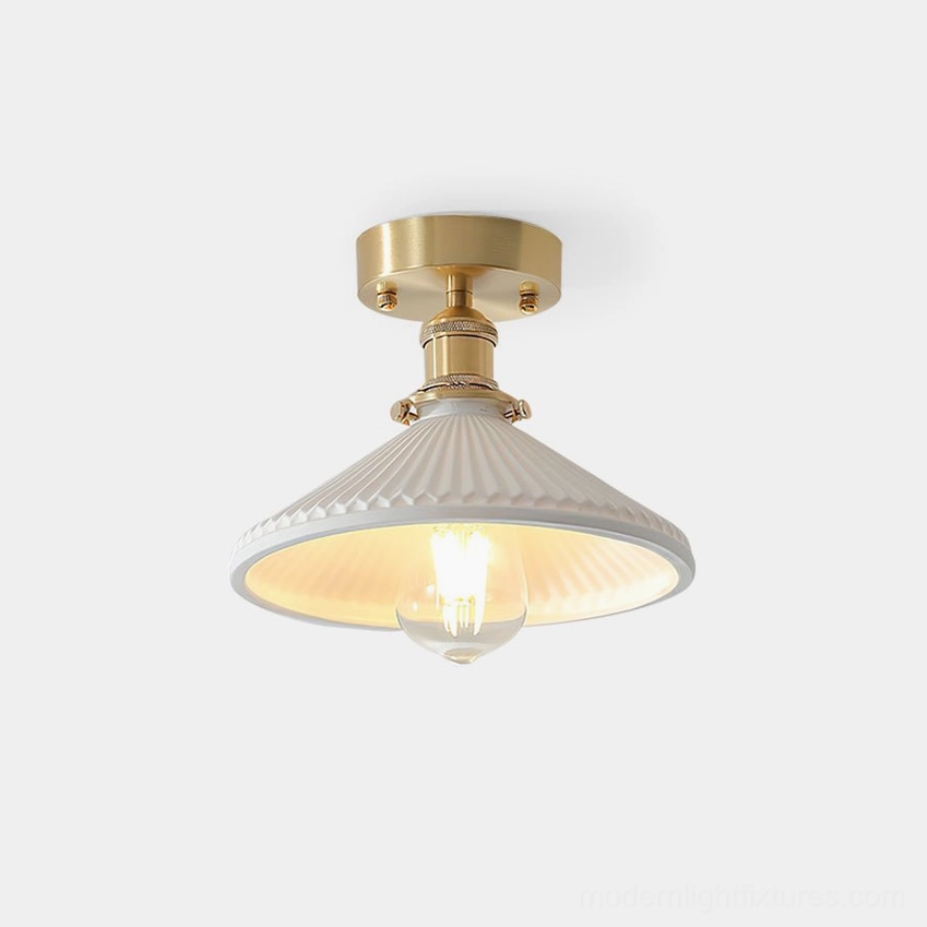 Rialto semi-flush ceiling light fixture with brushed gold mounting and white ribbed ceramic shade in studio setting