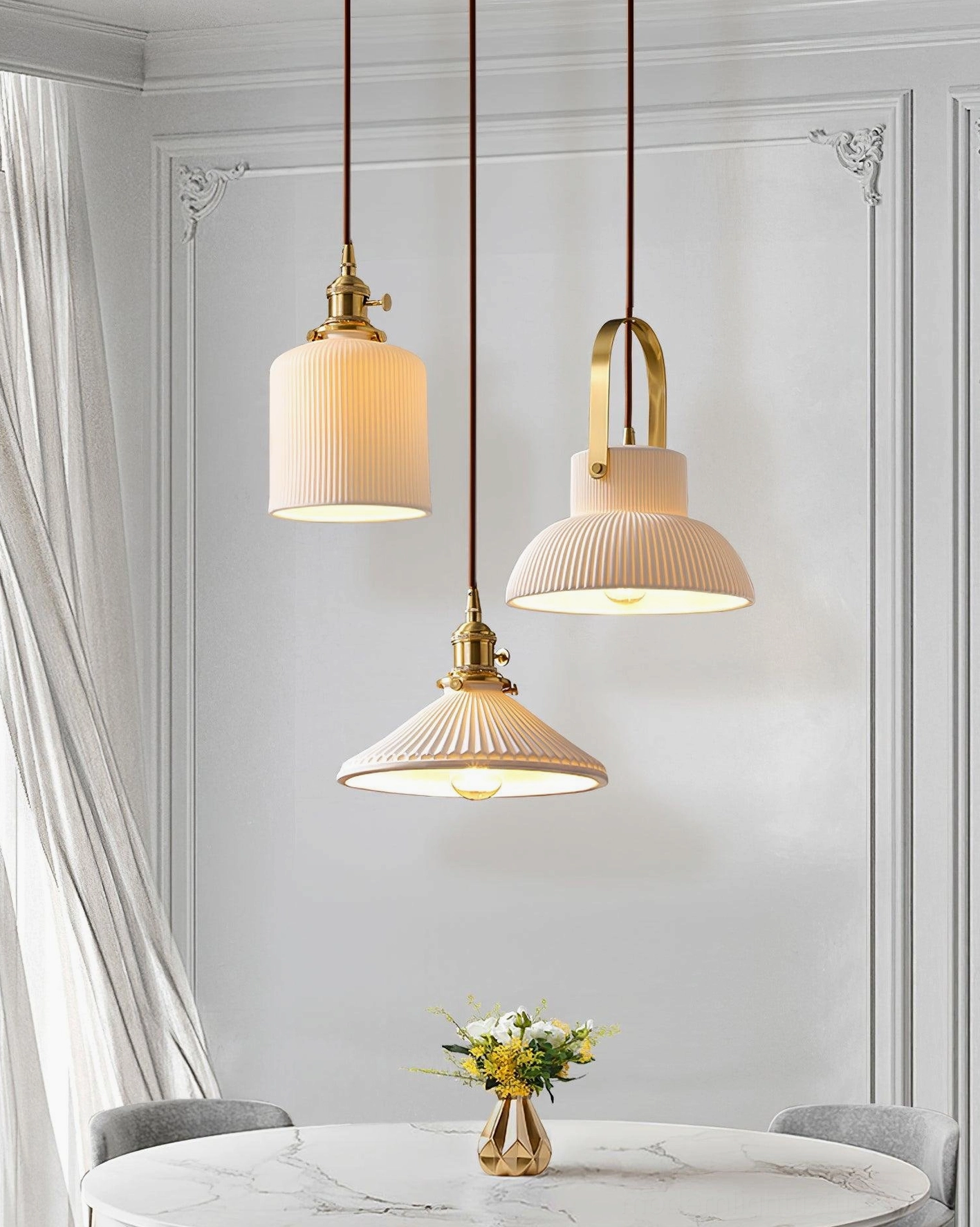 Three decorative ribbed ceramic pendant fixtures above marble dining table in modern home