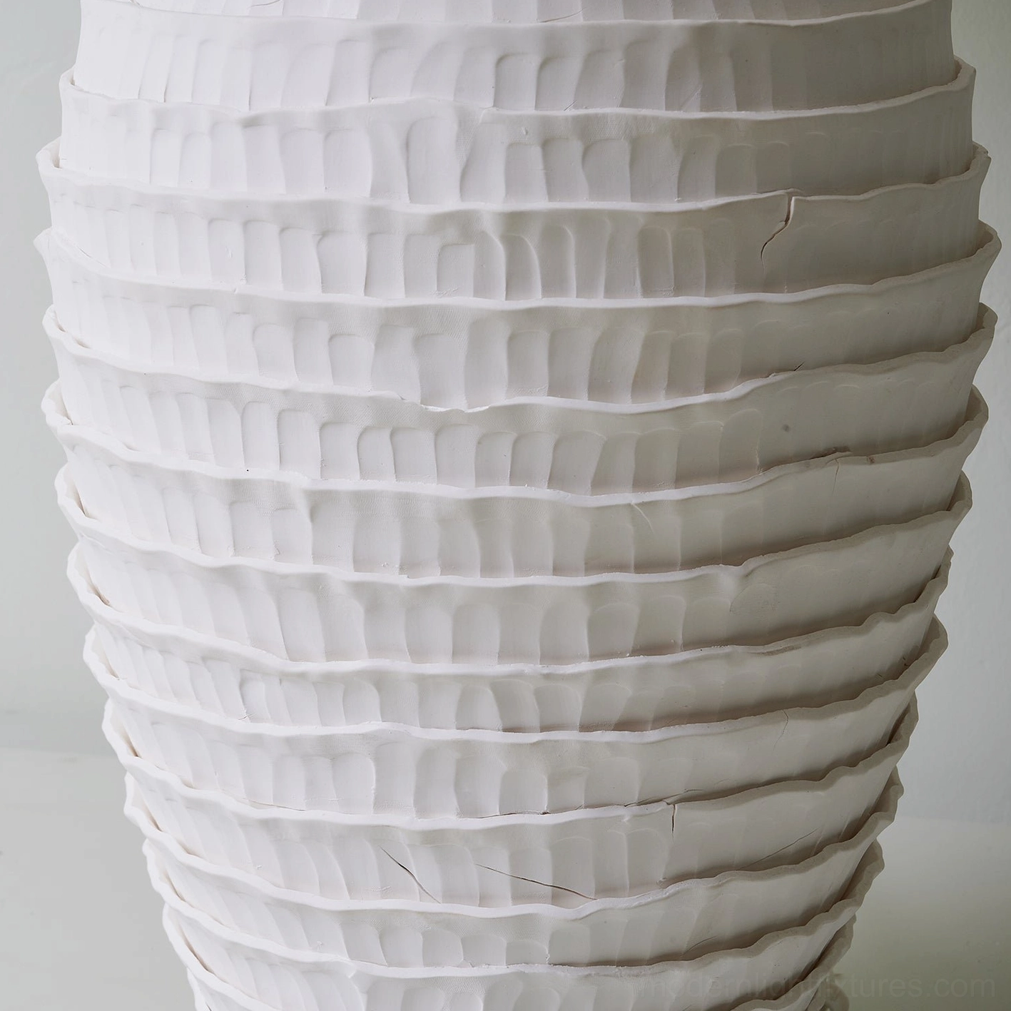 Magnified close-up of sculptural ribbed ceramic texture on lamp base showing matte white finish detail