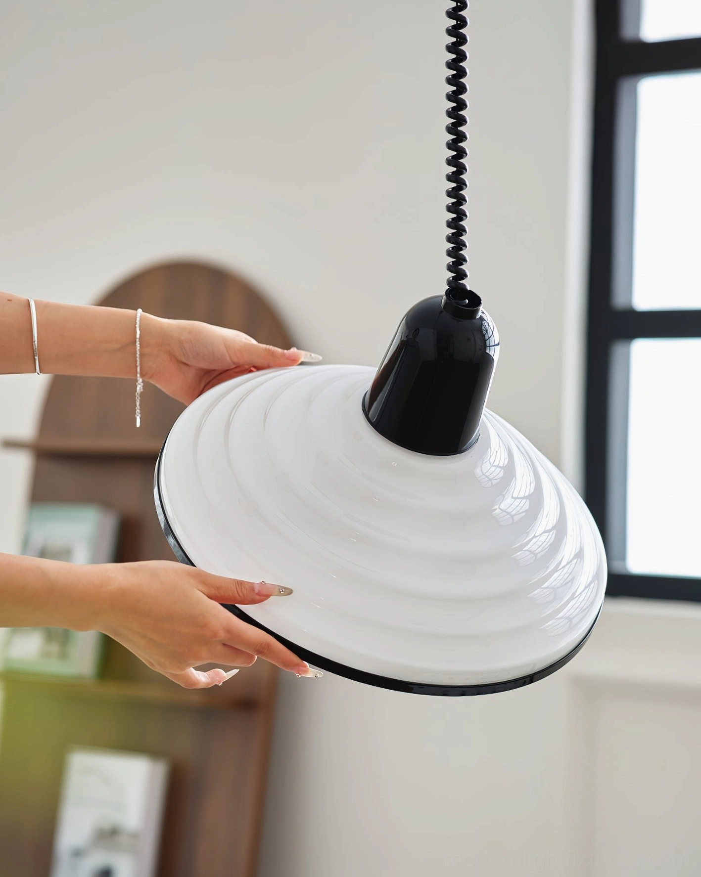 Side view of ribbed pendant lamp shade detail with black top fixture and coiled suspension cord