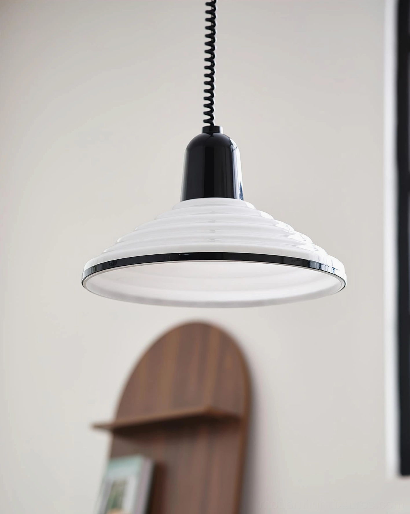 White ribbed pendant light hanging above wooden wall shelf in cozy home interior with minimalist retro design