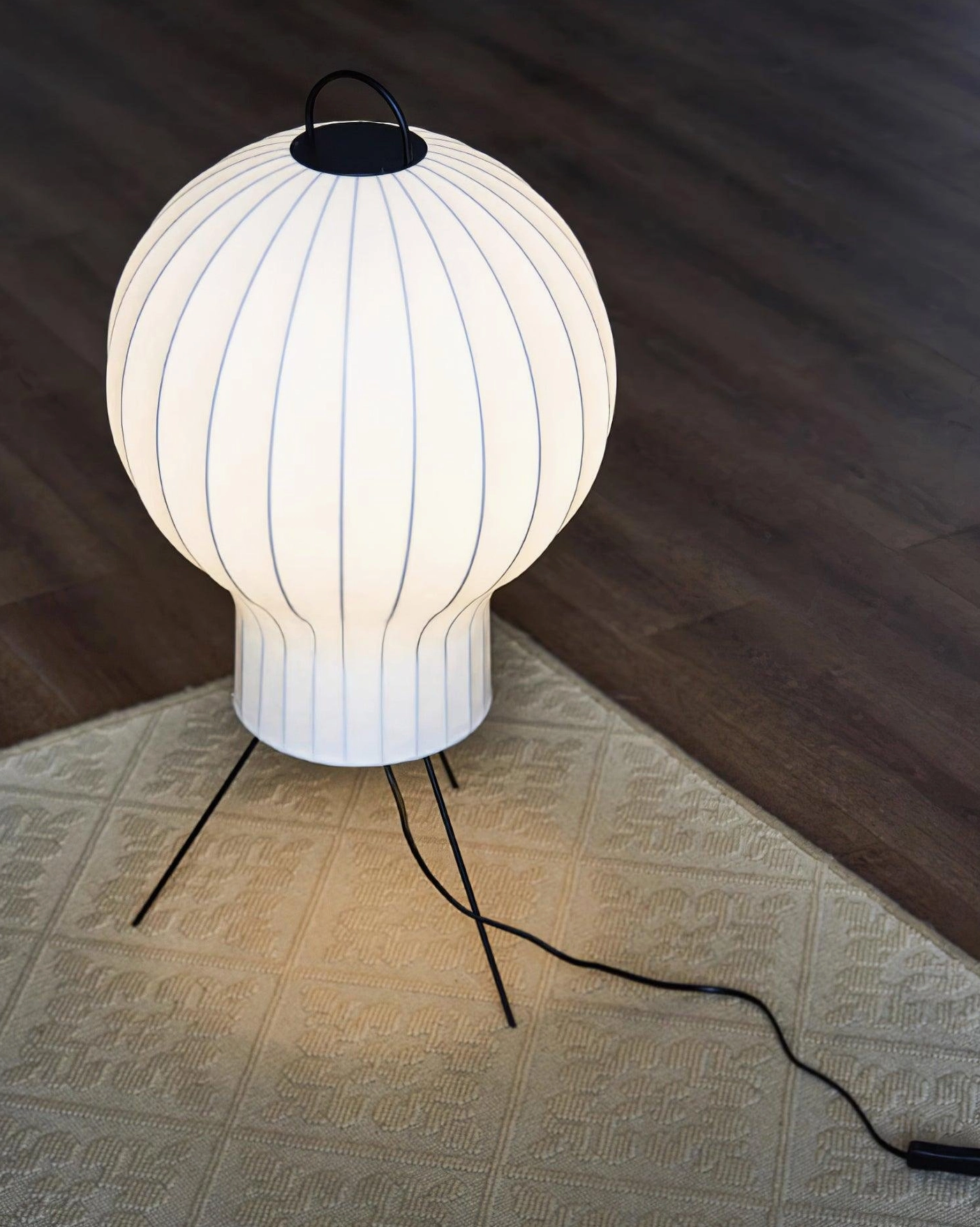 Ribbed silk shade floor lamp with metal tripod base in contemporary interior space