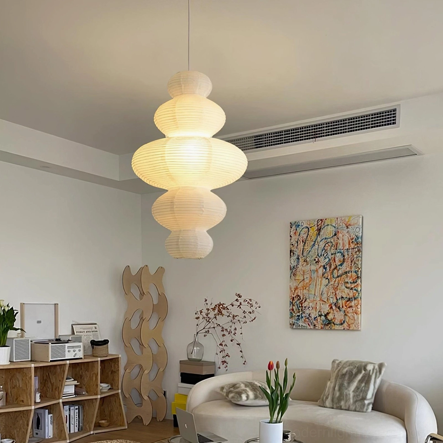 Modern pendant lamp installed in contemporary living room creating warm ambient light and glowing white fixture