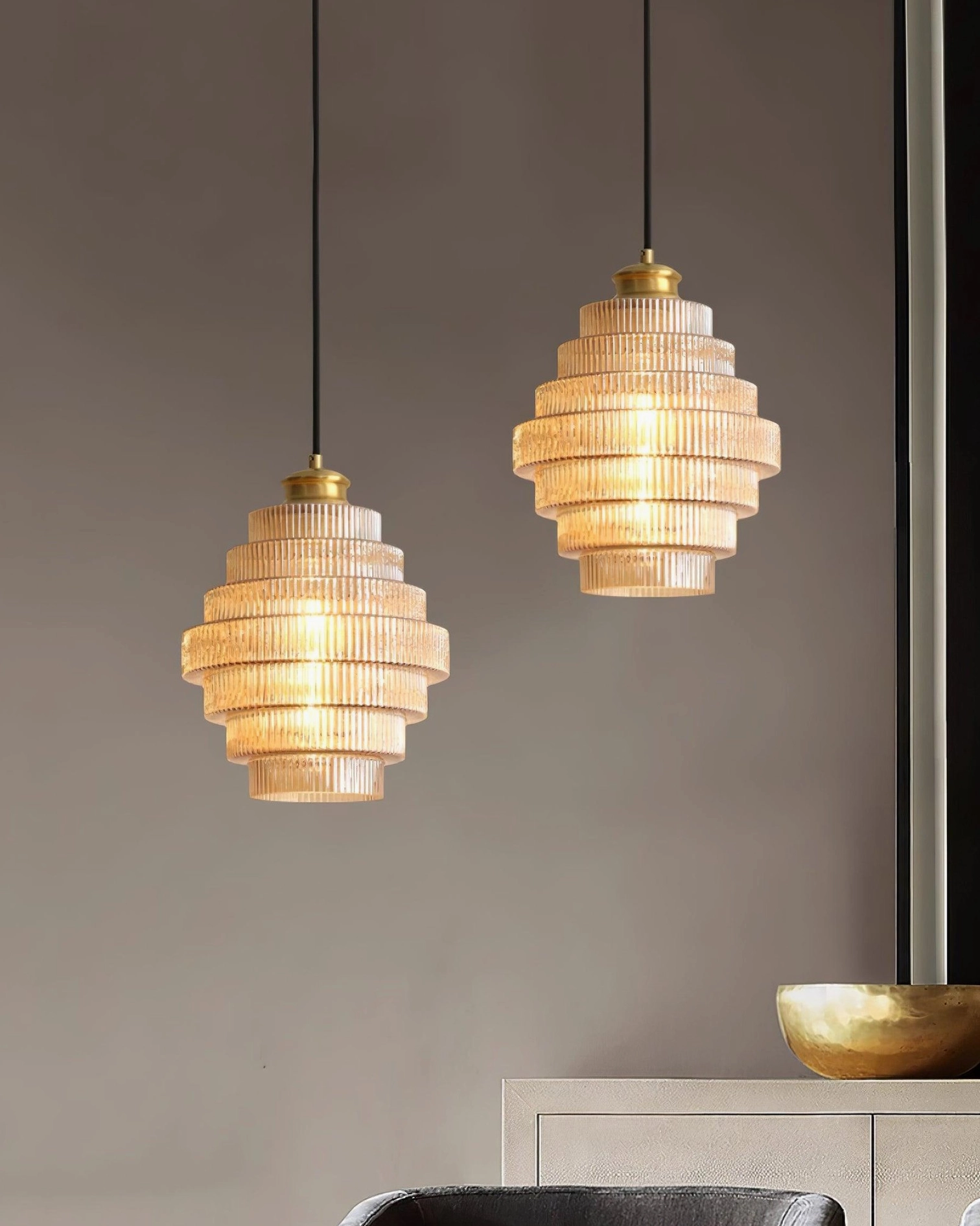 Layered lighting with ridged glass pendant light, floor lamp, and candles in living room
