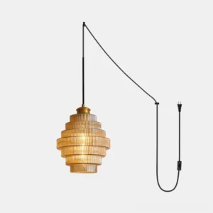 Modern ridged glass plug-in pendant light with amber finish and brass hardware on white studio background