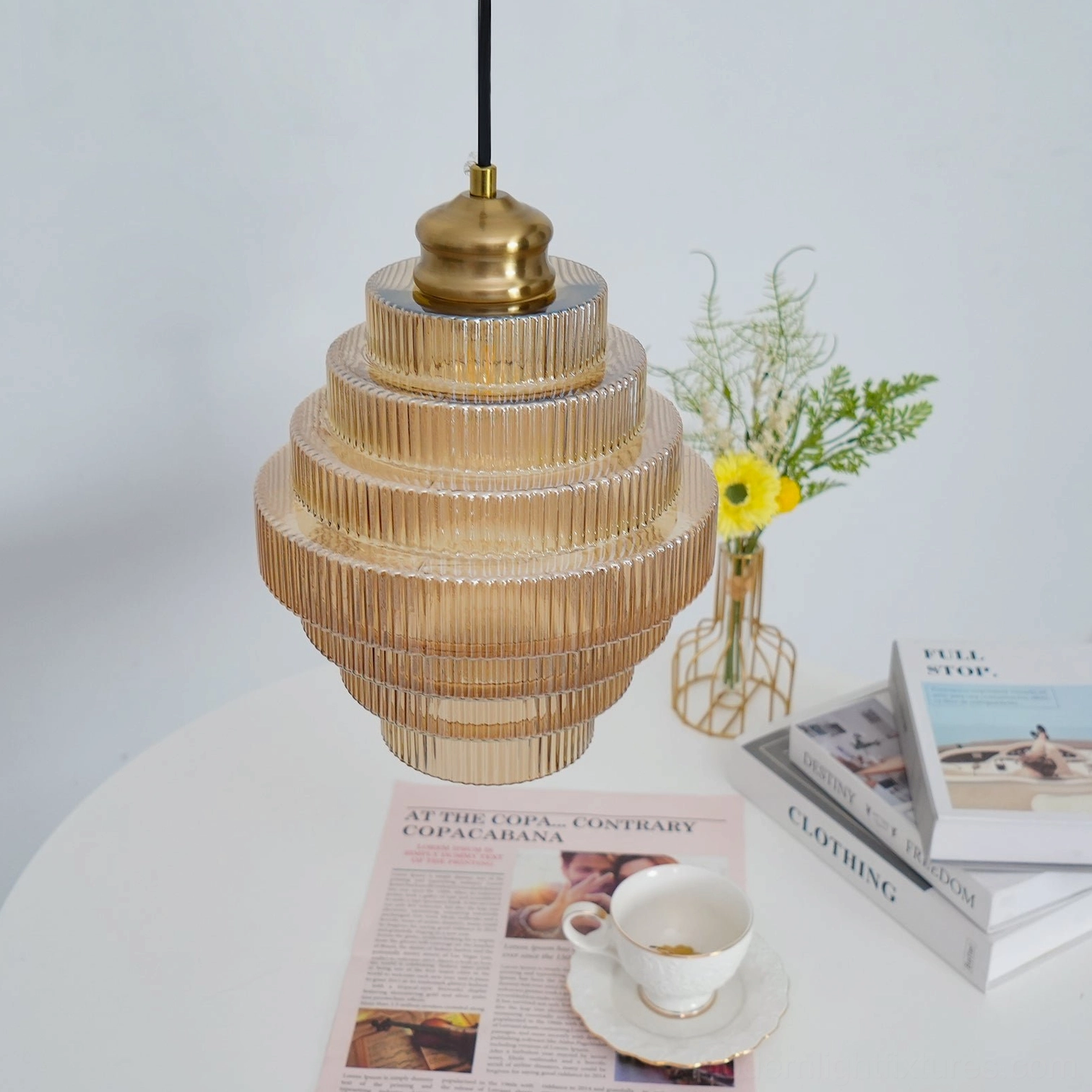 Ridged glass pendant light installation showing tiered glass structure and light diffusion effect