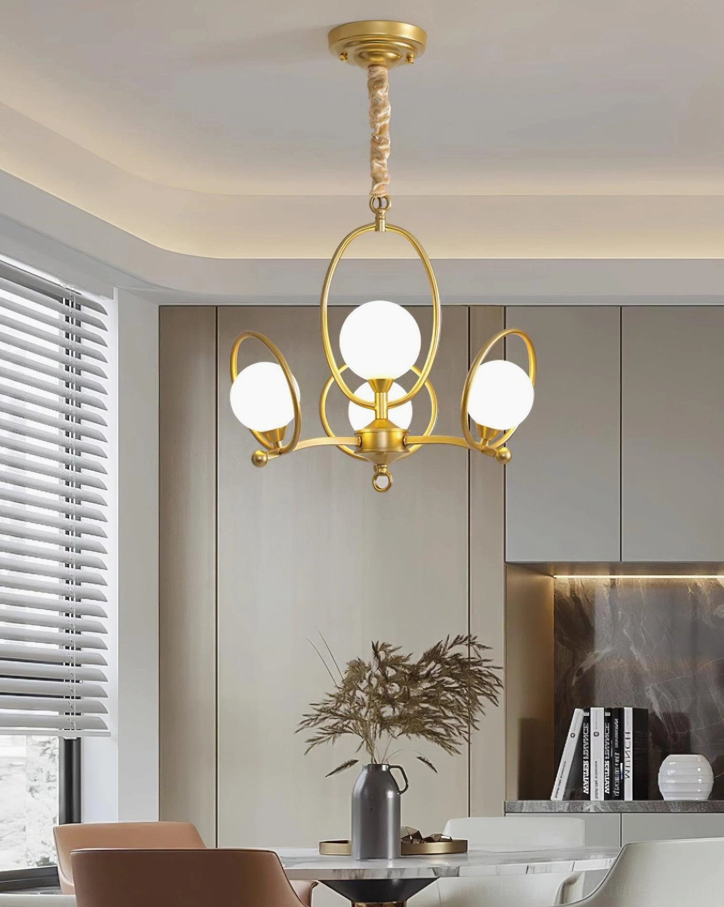 Riley multi-light pendant chandelier eye-level view in modern dining space with curved metal arms and glass globes