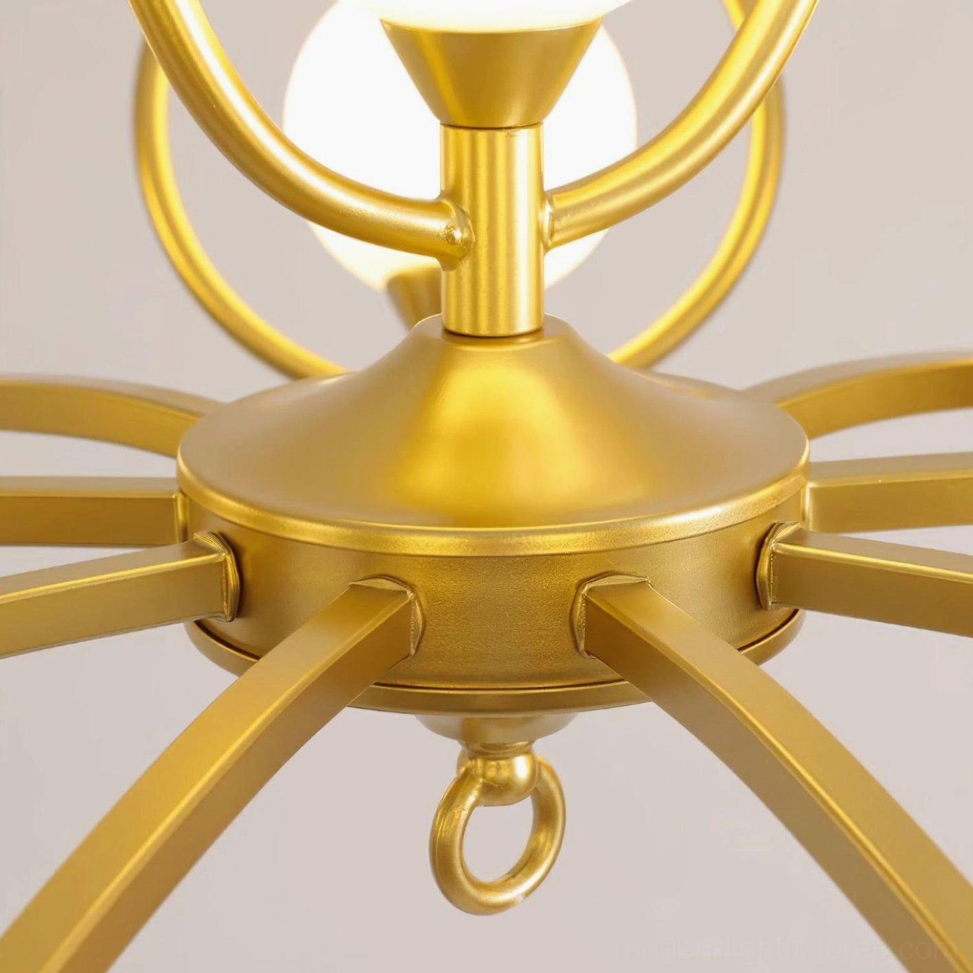 Riley chandelier base component close-up showing brushed gold metal construction and hanging loop detail