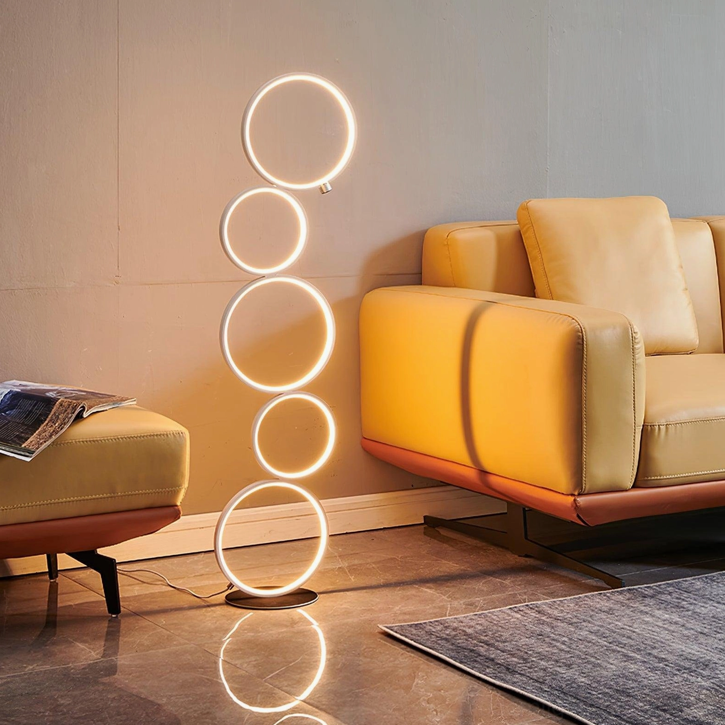 Contemporary circular floor lamp with illuminated rings beside yellow leather sofa in corner placement
