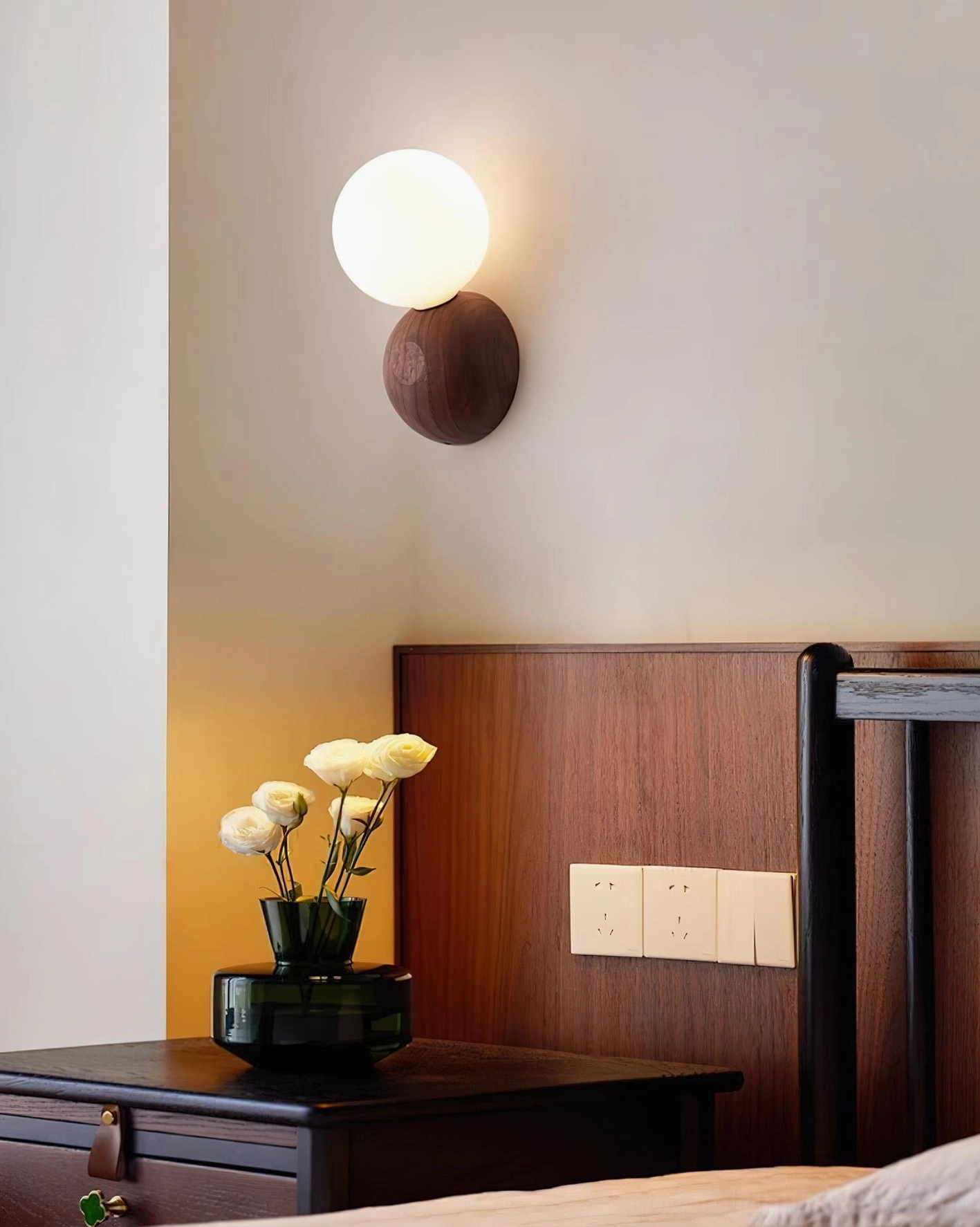 Ringo modern glass and wood wall lamp in contemporary bedroom setting with wooden headboard and side table styling