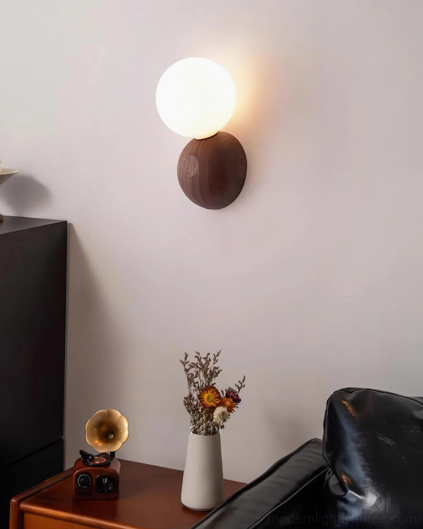 Ringo modern wall sconce in living room setting with mid-century furniture and dried flower botanical decor