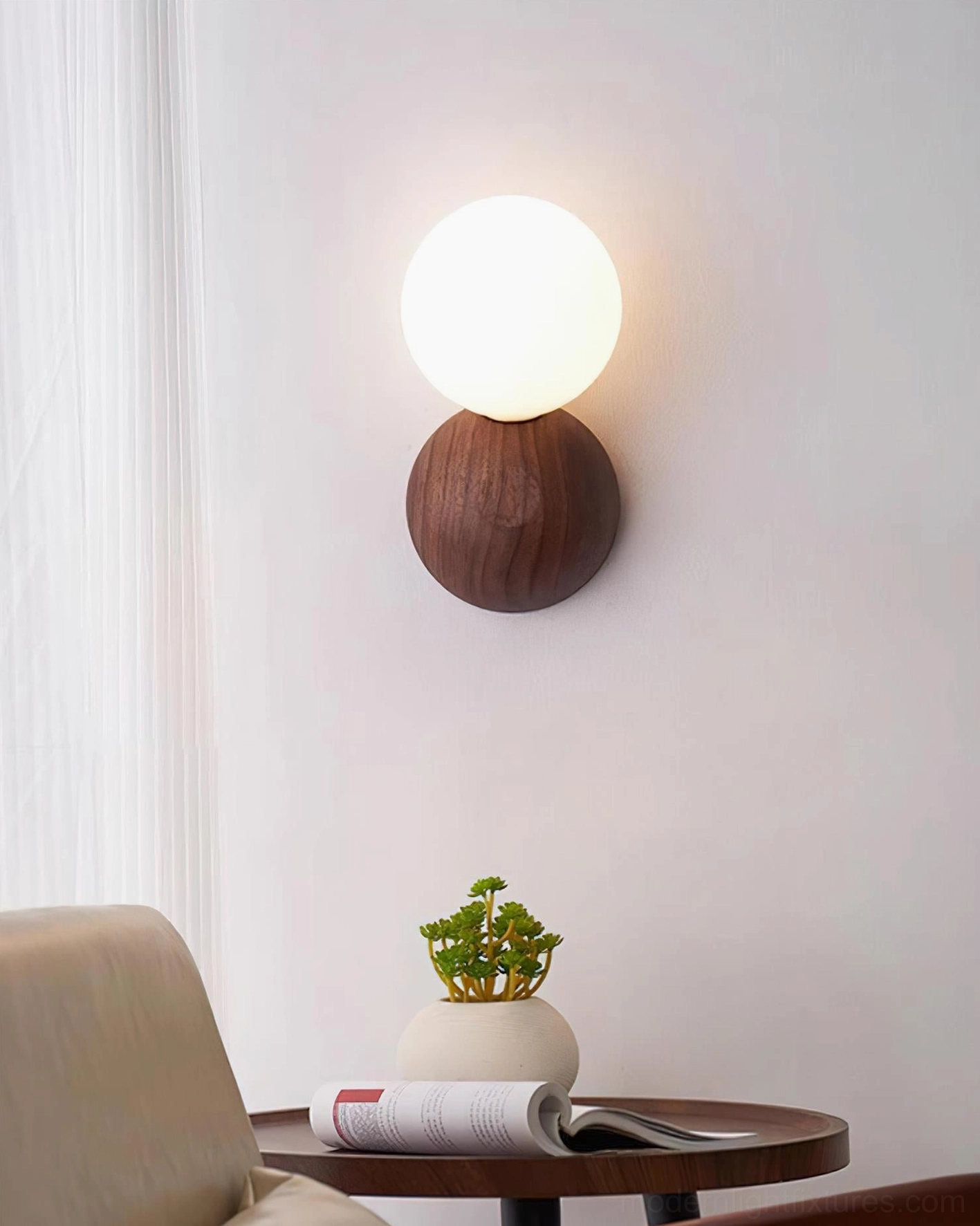 Ringo wall sconce in minimalist living room corner with table plant and open book, minimalist ambiance