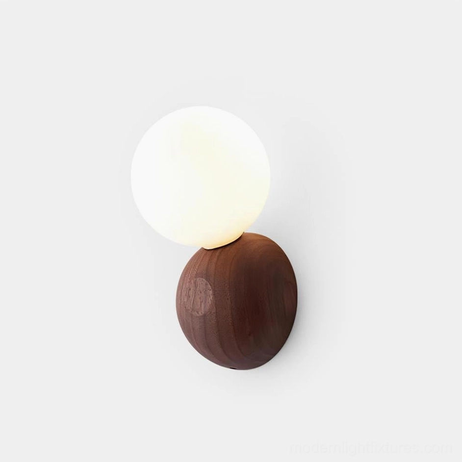 Ringo modern wood and glass wall sconce with walnut finish on minimalist white wall, front view showing opal glass diffuser
