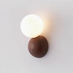 Illuminated Ringo hardwired wall lamp showing warm light diffusion through opal glass globe, close-up detail