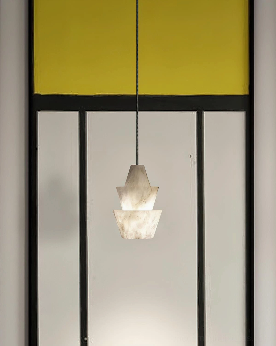 Single rinkle alabaster pendant light glowing warmly in front of glass partition walls with yellow accent panels, modern room front view