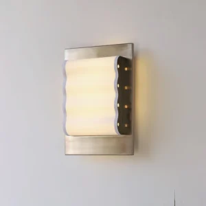 Contemporary ripple edge wall lamp with smooth wavy shade and brushed metal base white studio lighting