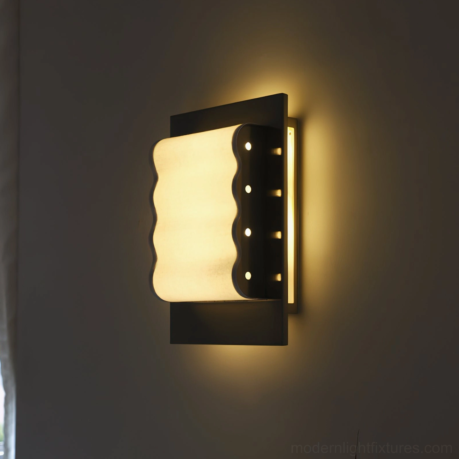 Ripple edge wall sconce mounted on dark wall with warm glowing light and matte black metal frame