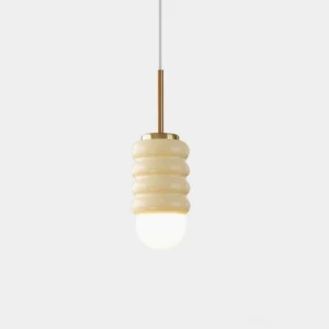 Ripple Glow ceramic pendant lamp with beige corrugated shade and brass gold hardware, studio view with warm spherical bulb