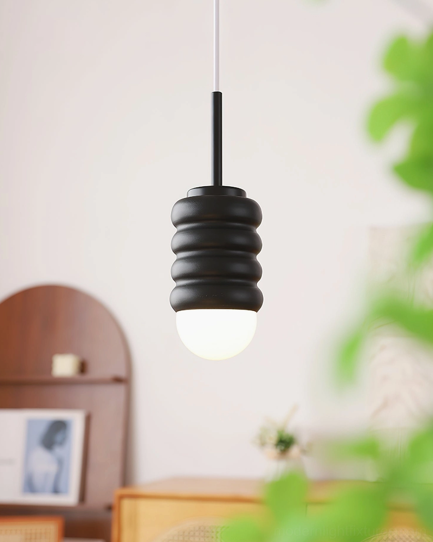 Matte black metal pendant lamp with corrugated shade, contemporary home interior display with warm illumination