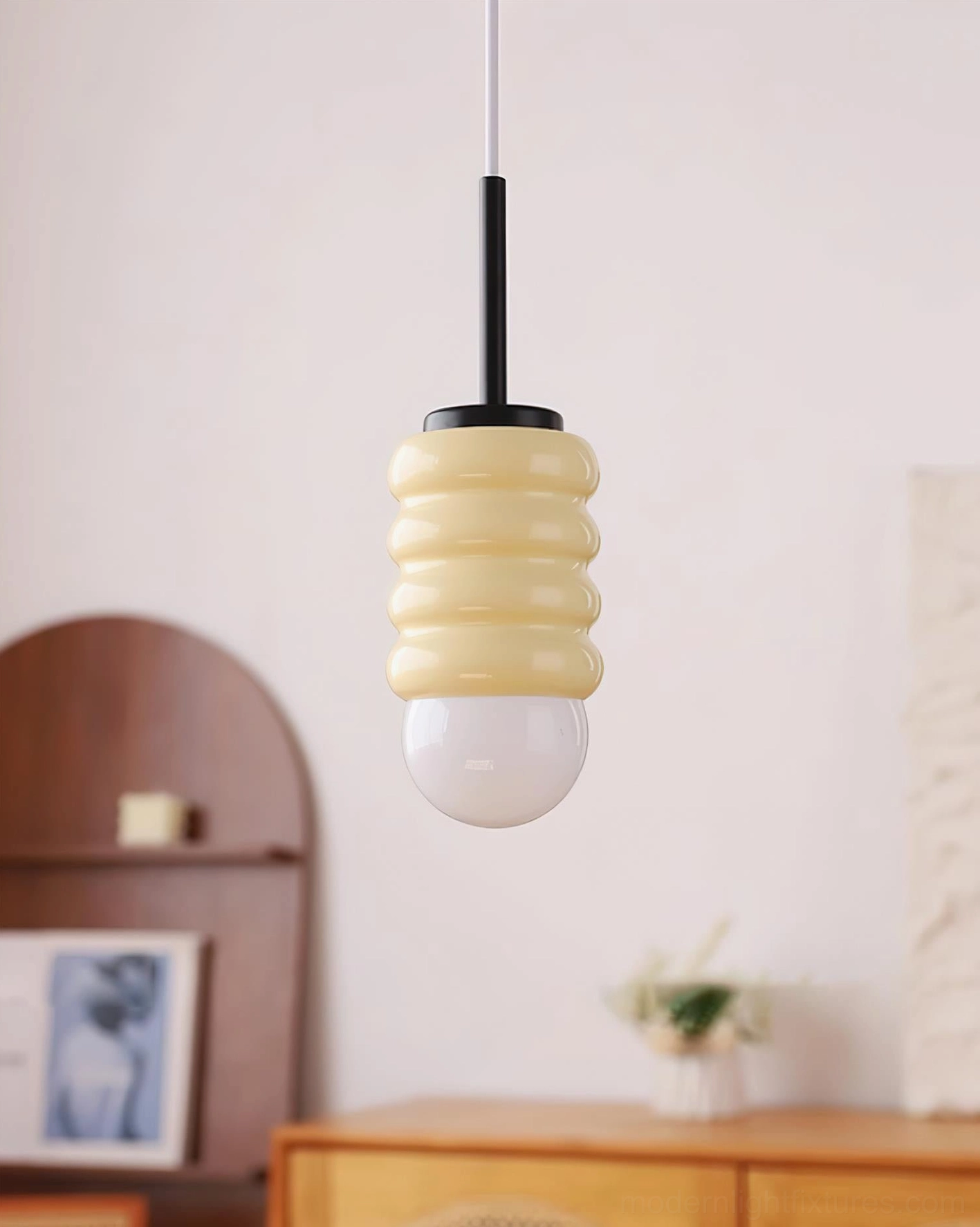 Cream ceramic pendant lamp with black metal hardware in vintage bedroom ambiance, unlit design view