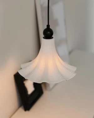 Florin Ripple pendant lamp with pleated ceramic shade and black metal fixture in Nordic minimalist home interior, side view at eye level
