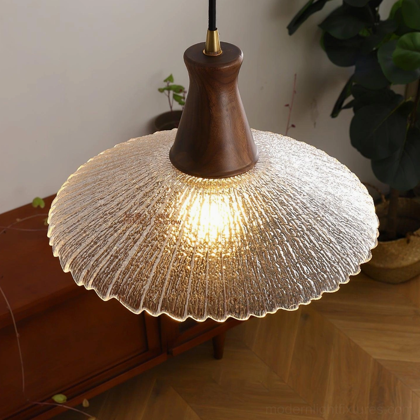 Close-up overhead view of ribbed glass shade pendant lamp showing texture and brass mounting detail